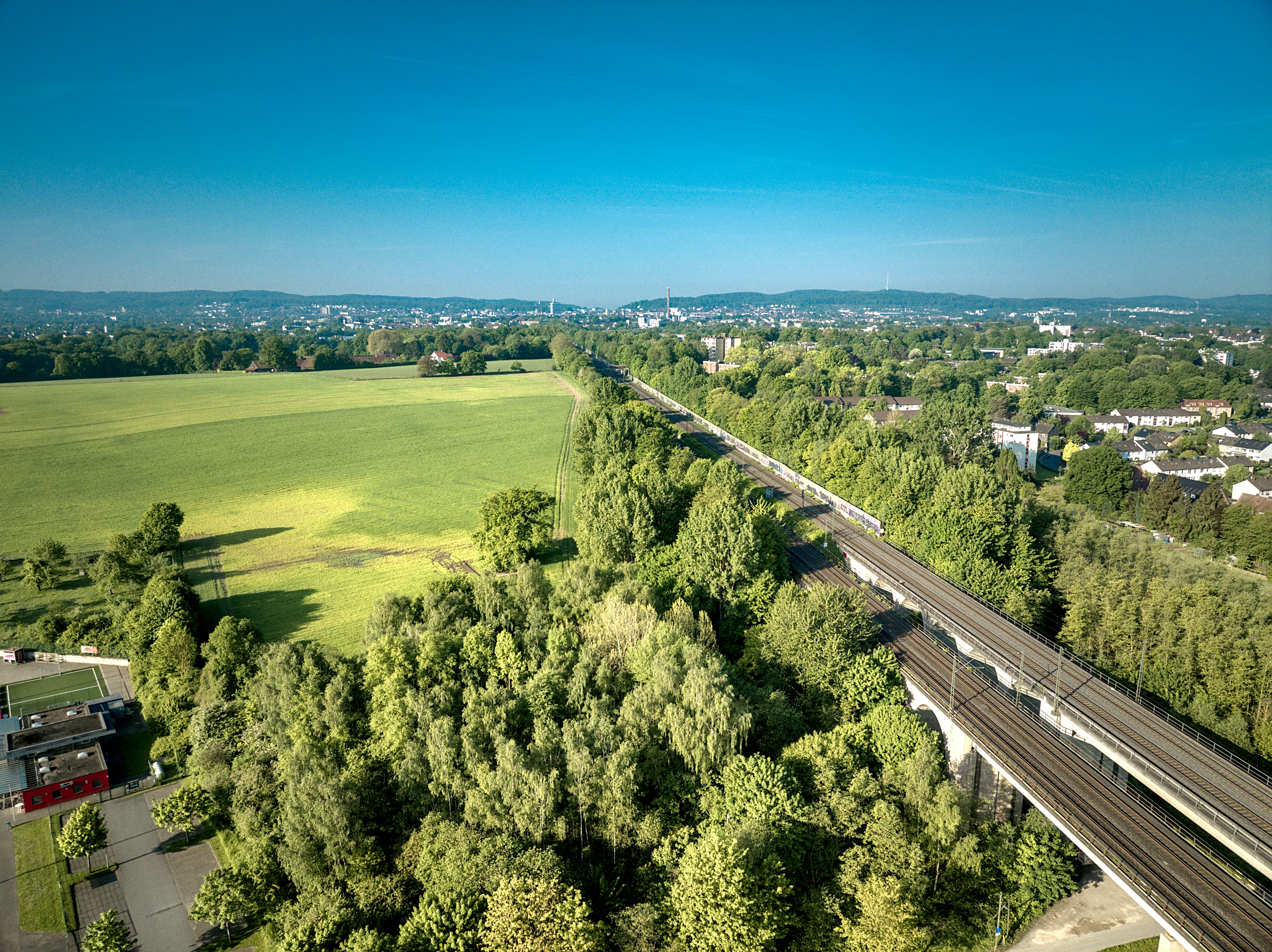 An aerial view of a highway in the middle of a green field