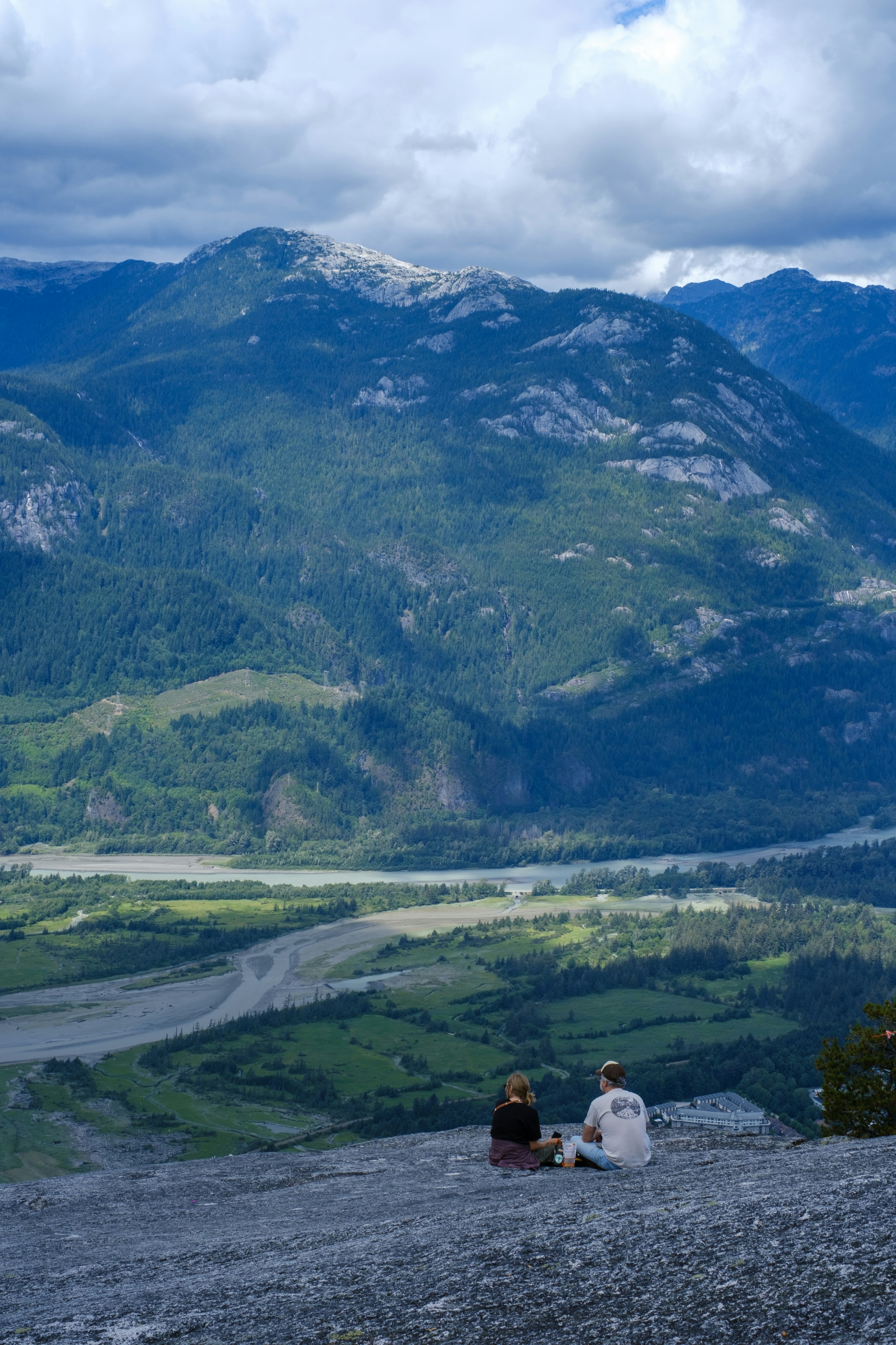 Ein paar Leute sitzen auf dem Gipfel eines Berges