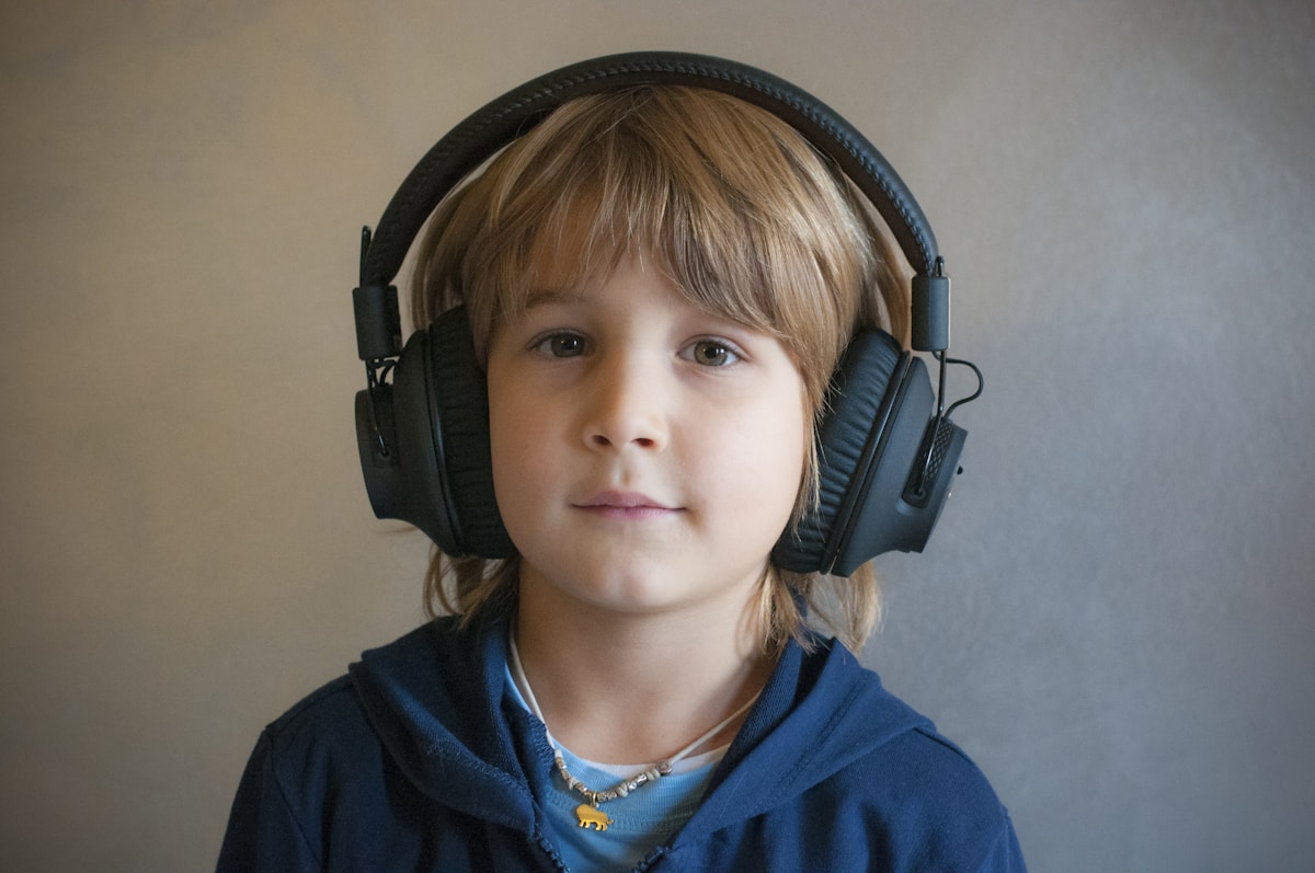 A young boy with headphones on his ears