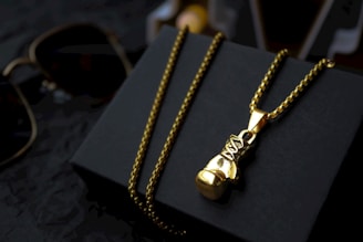 A pair of glasses and a necklace on a black box