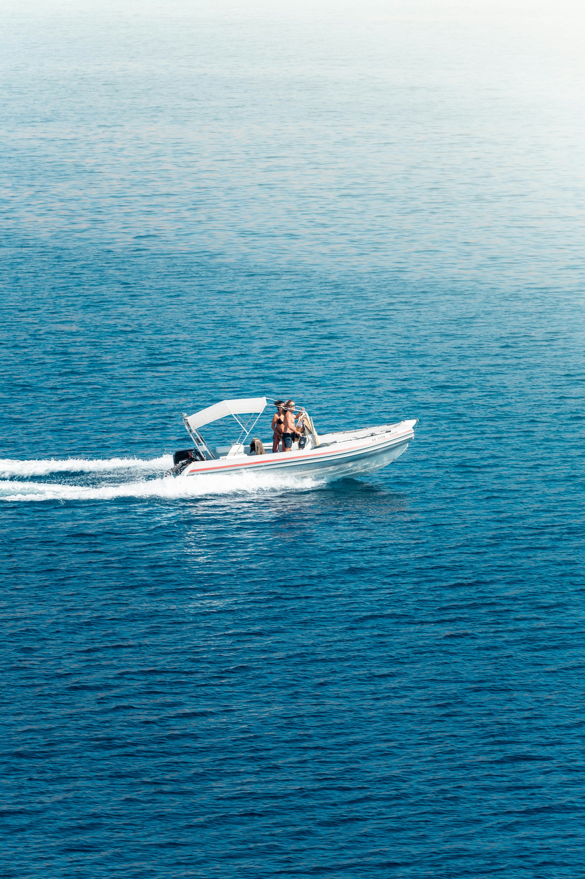 A man riding on the back of a white boat