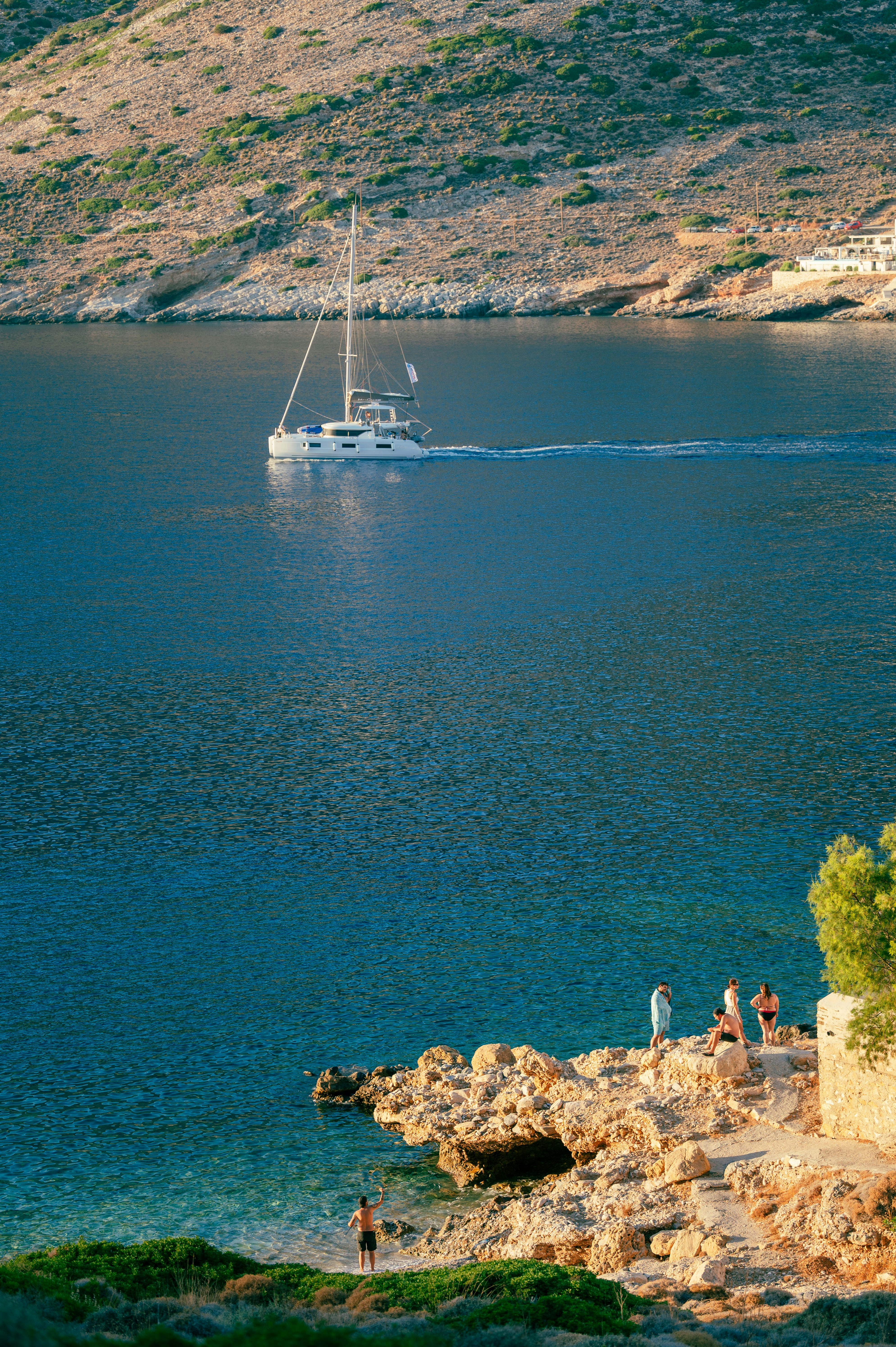 A boat is in the water near a rocky shore