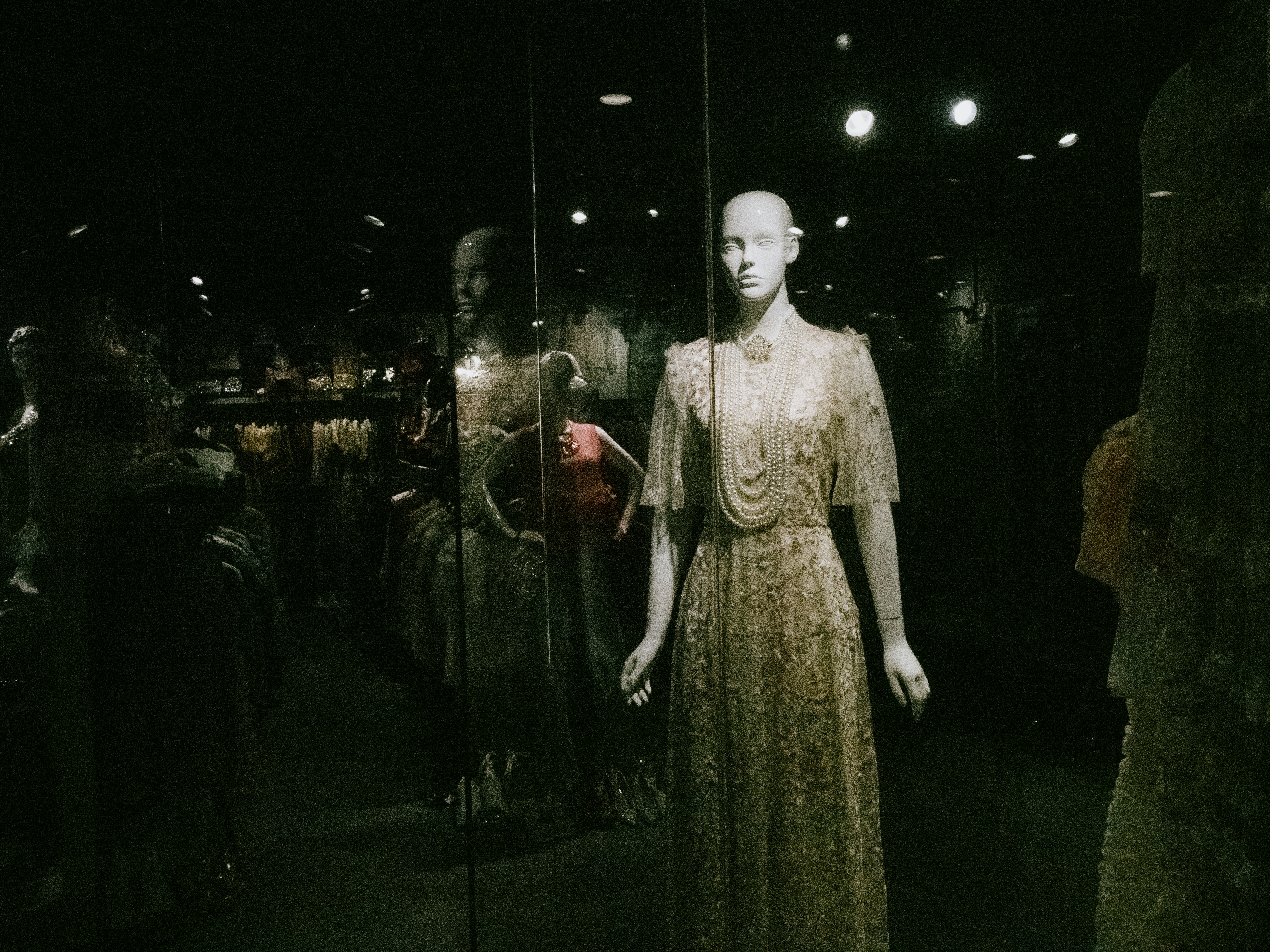 A mannequin is standing in front of a display of mannequins