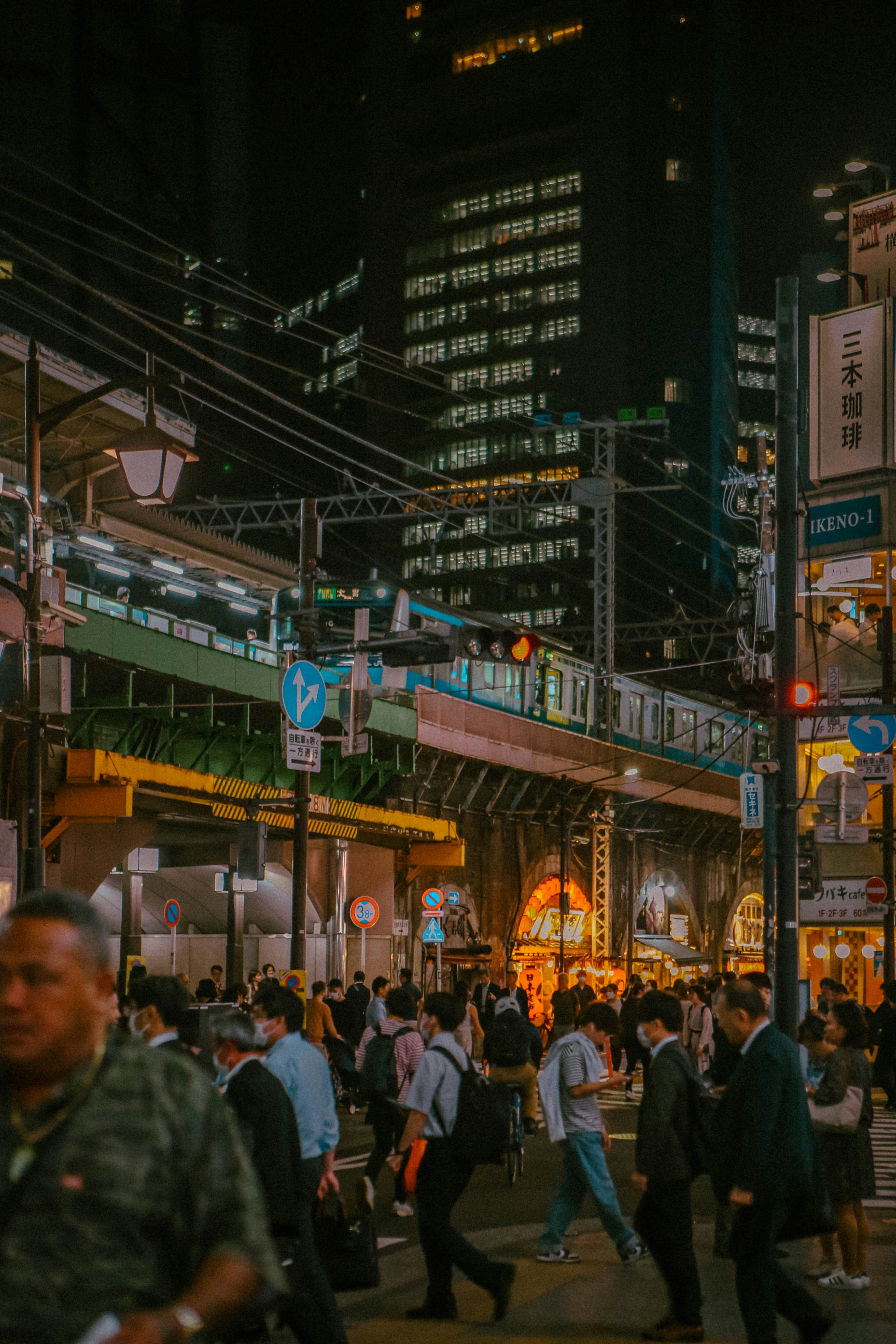 A crowded city street at night with people crossing the street