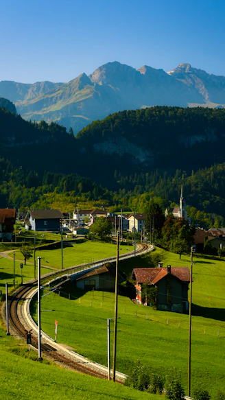 A scenic view of a small town with mountains in the background