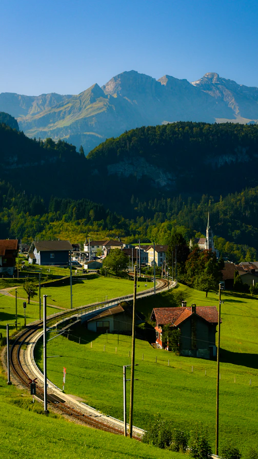 A scenic view of a small town with mountains in the background
