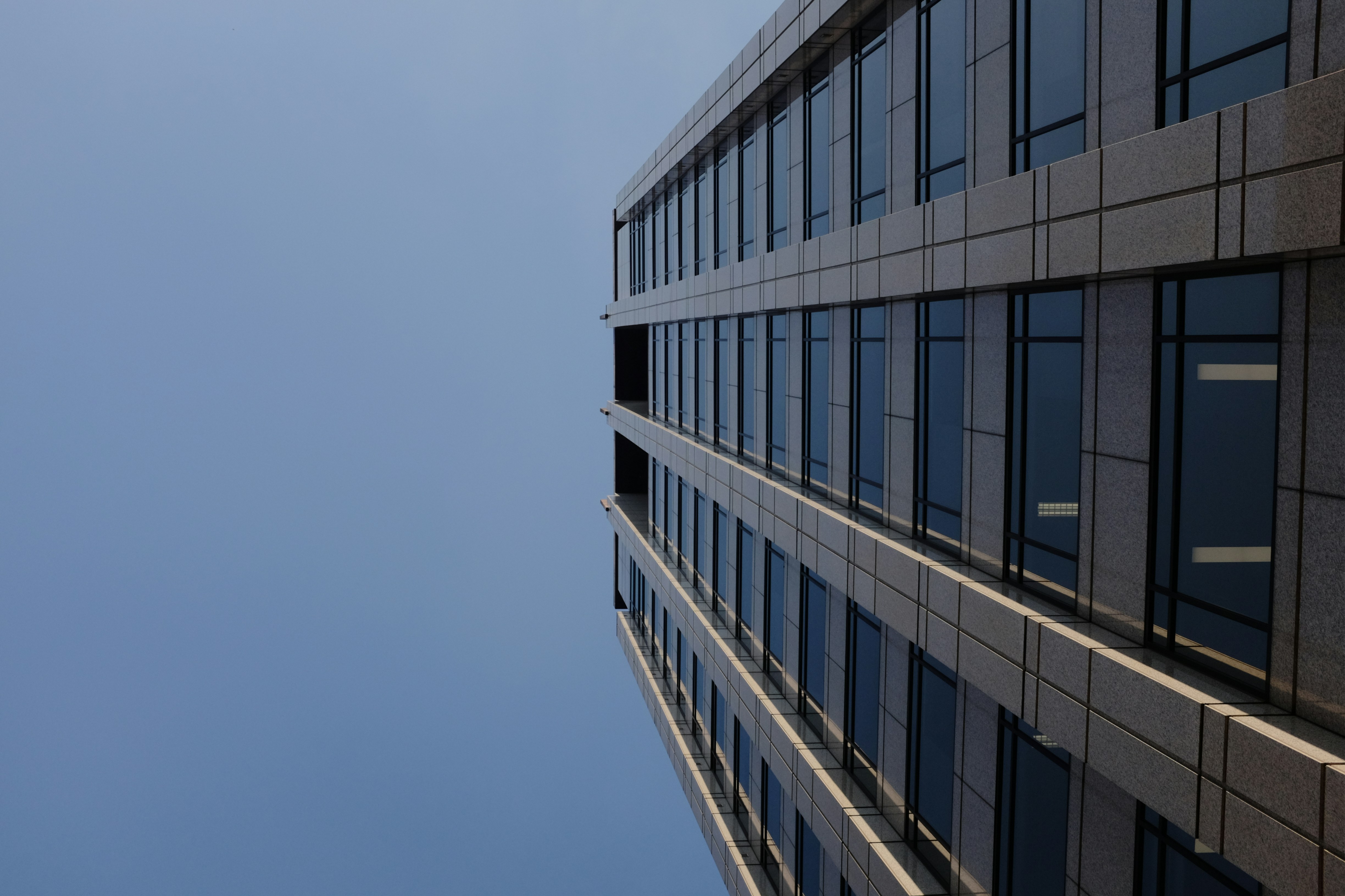 A tall building with a plane flying in the sky