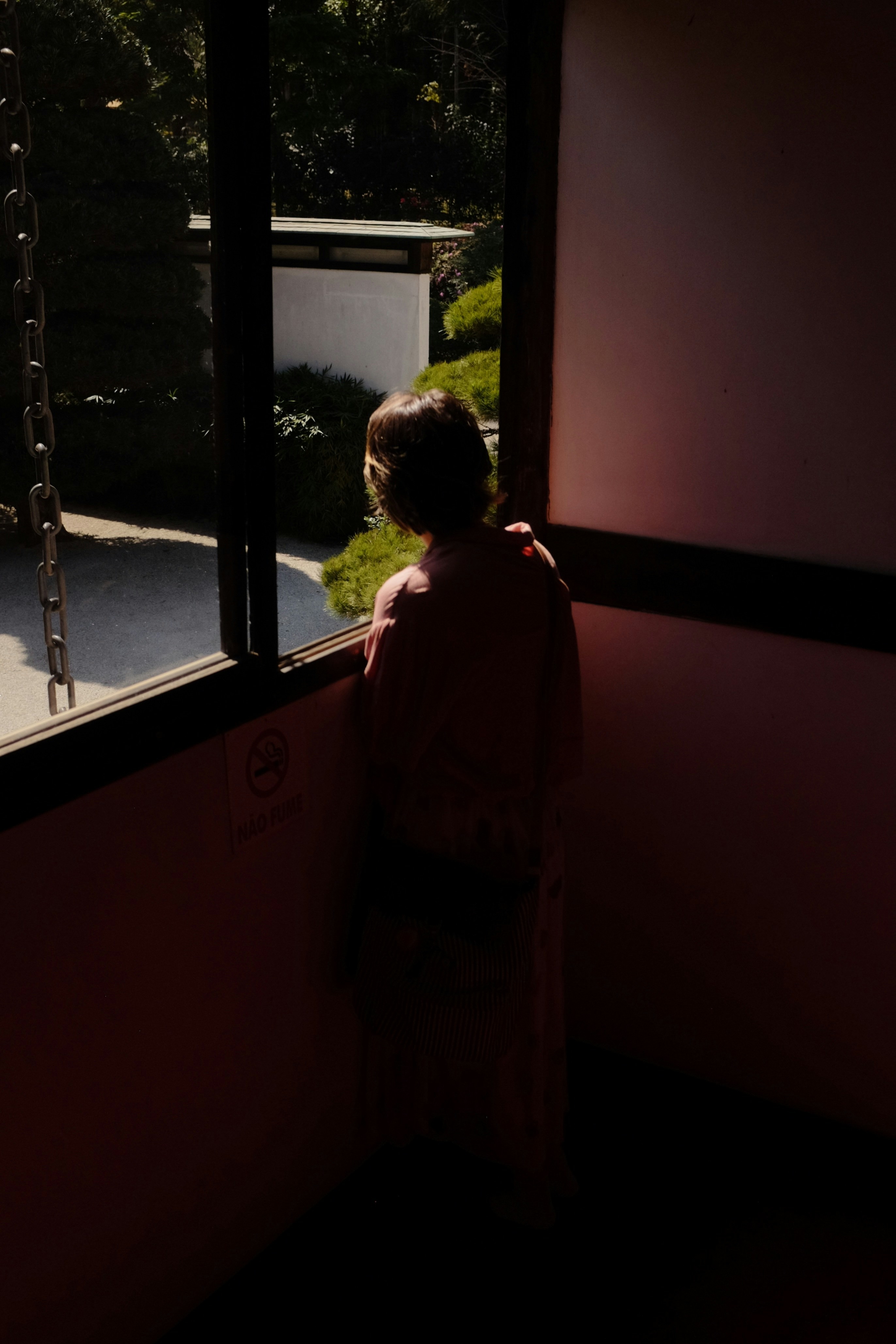 A woman standing in front of a window in a dark room