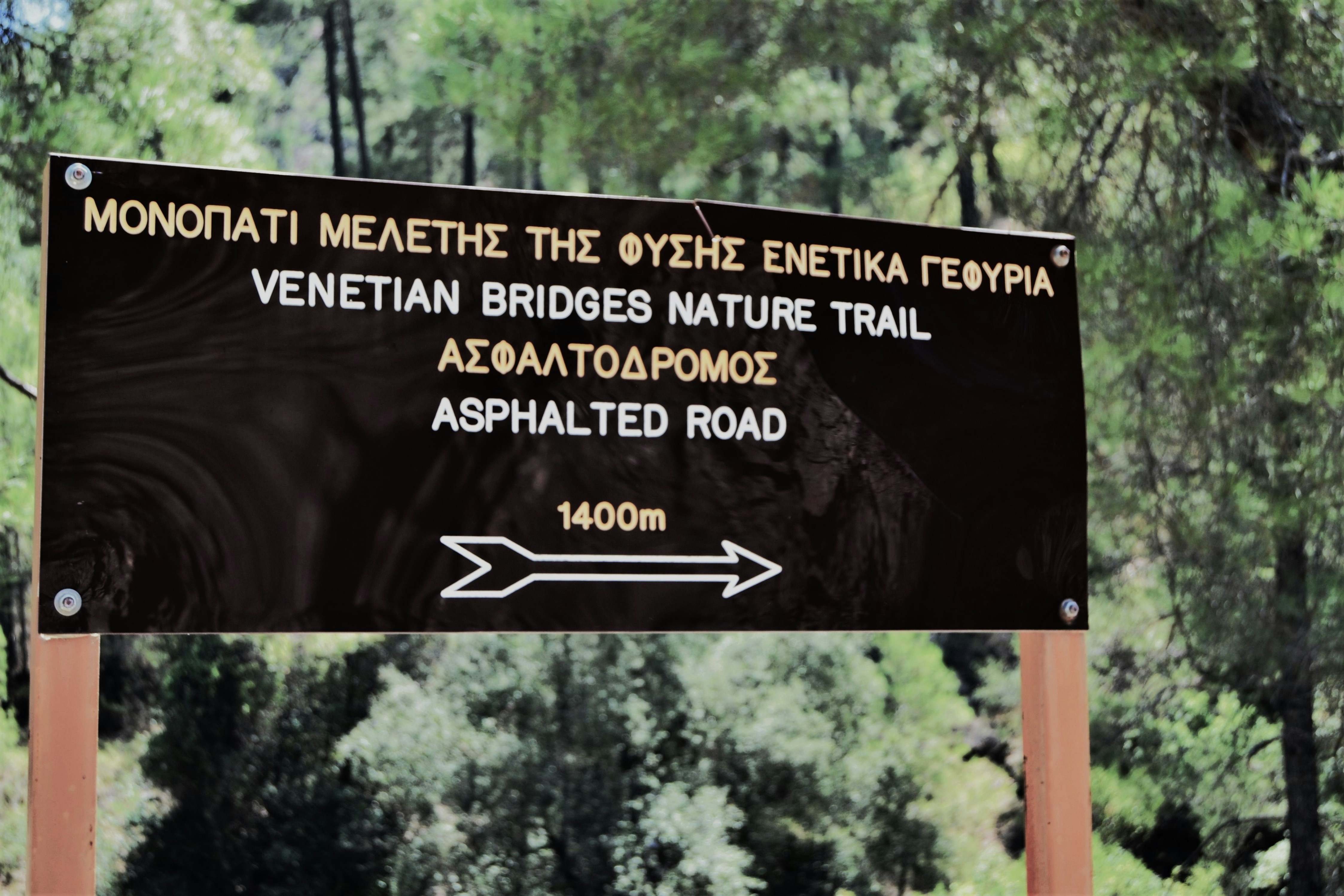 A sign in the middle of a wooded area