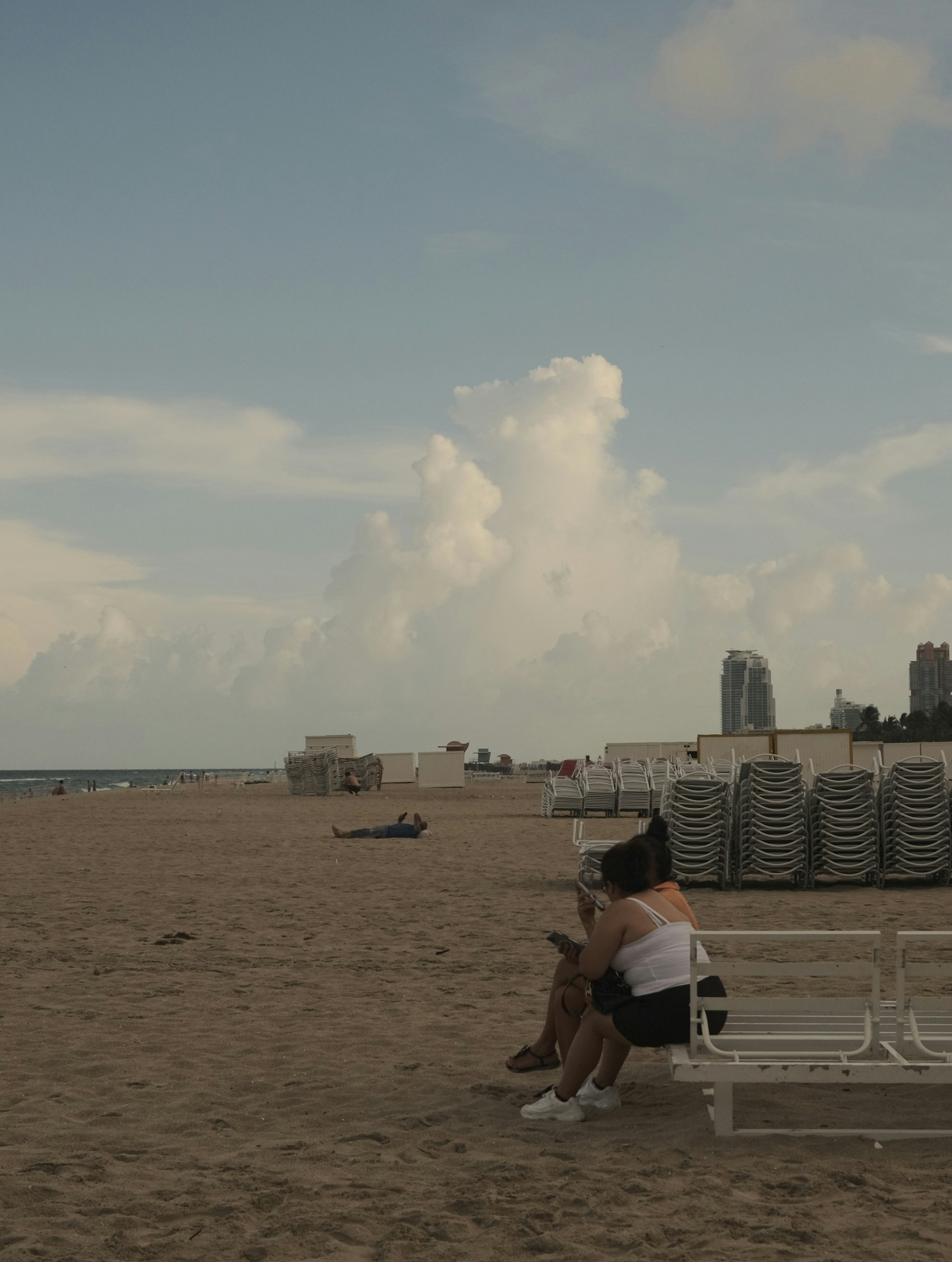 A person sitting on a bench on a beach photo – Free Beach Image on Unsplash