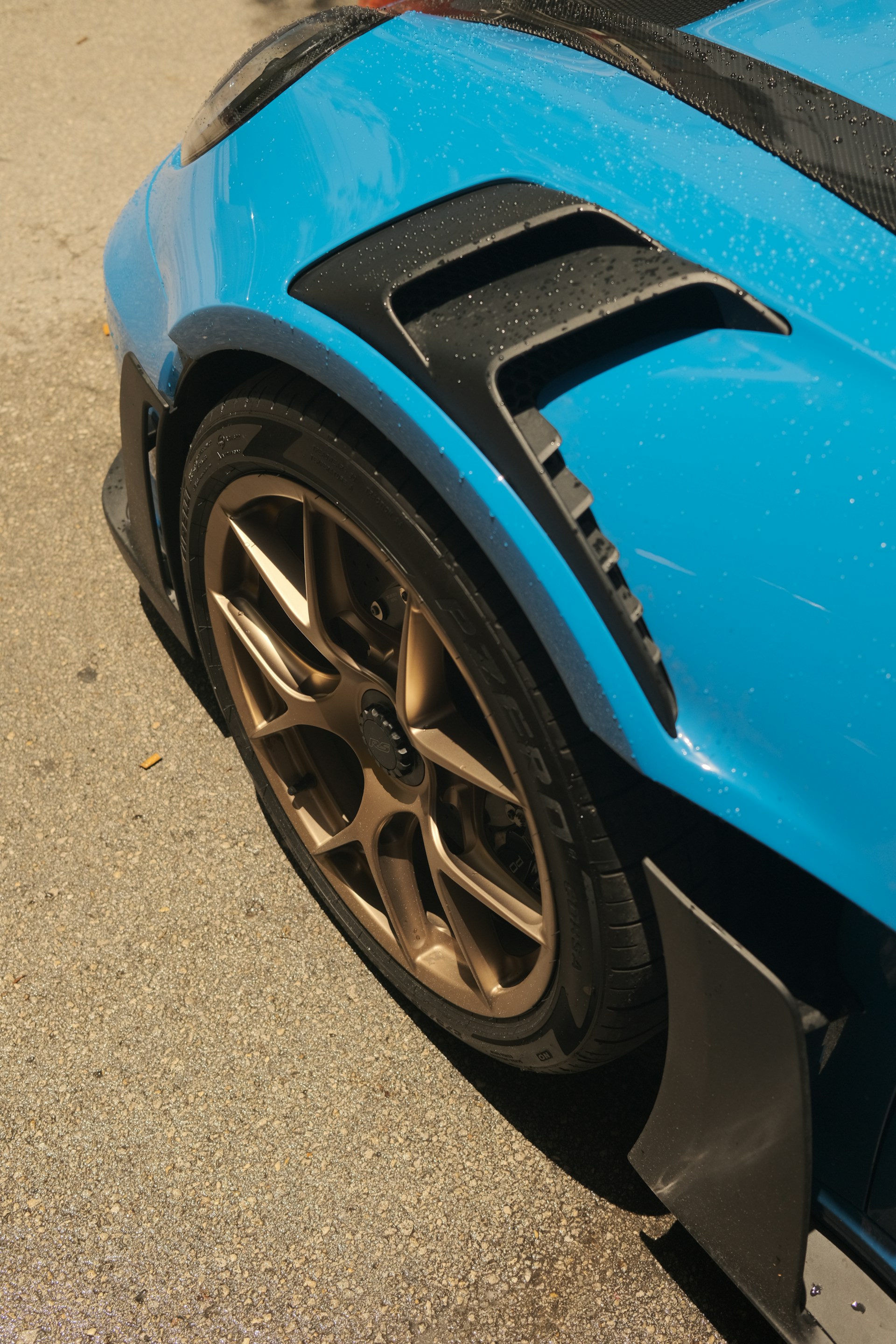 A close up of the front of a blue sports car