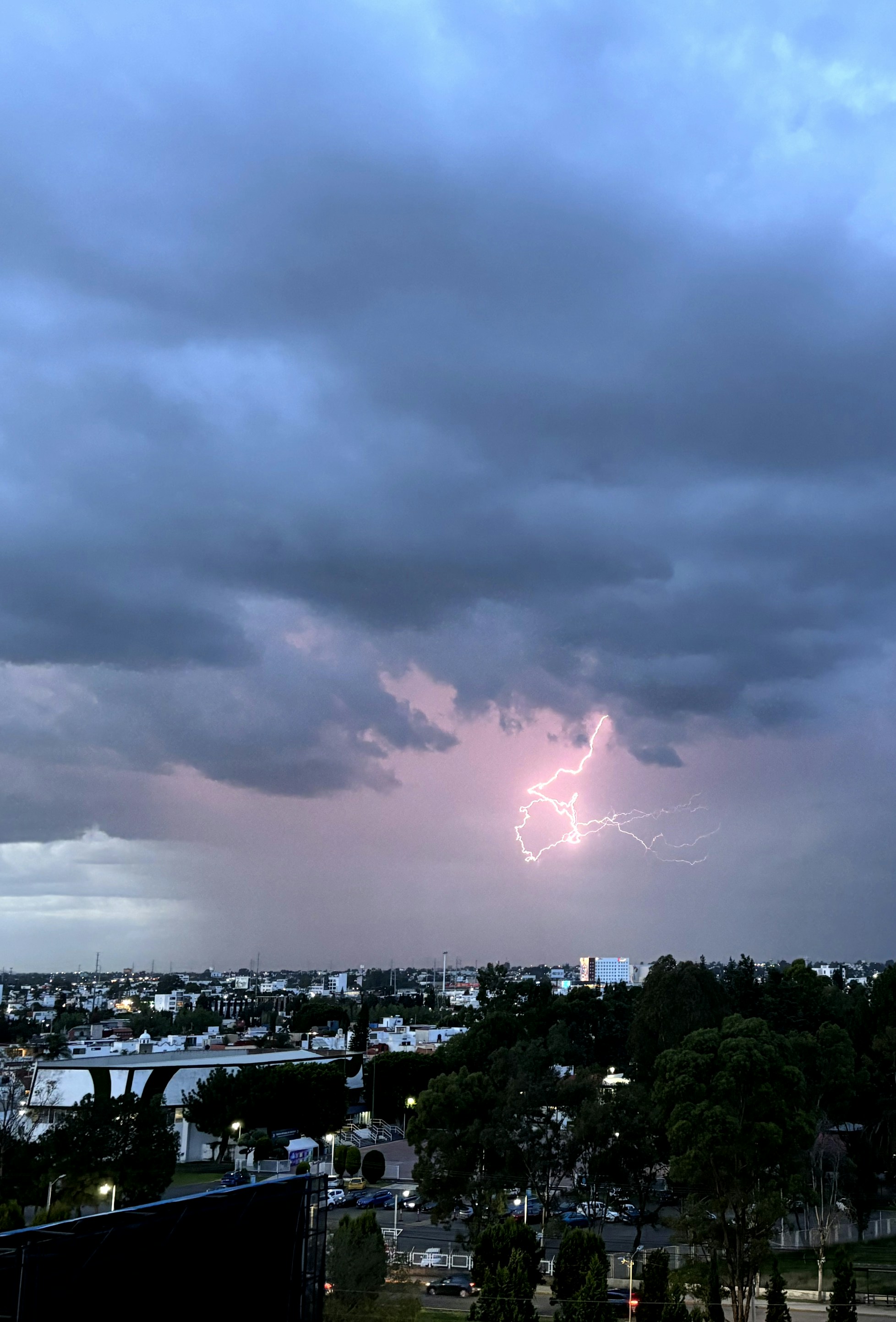 A lightning bolt is seen in the sky over a city