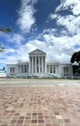 A large white building with columns and a sky background