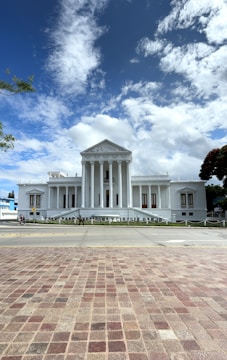A large white building with columns and a sky background