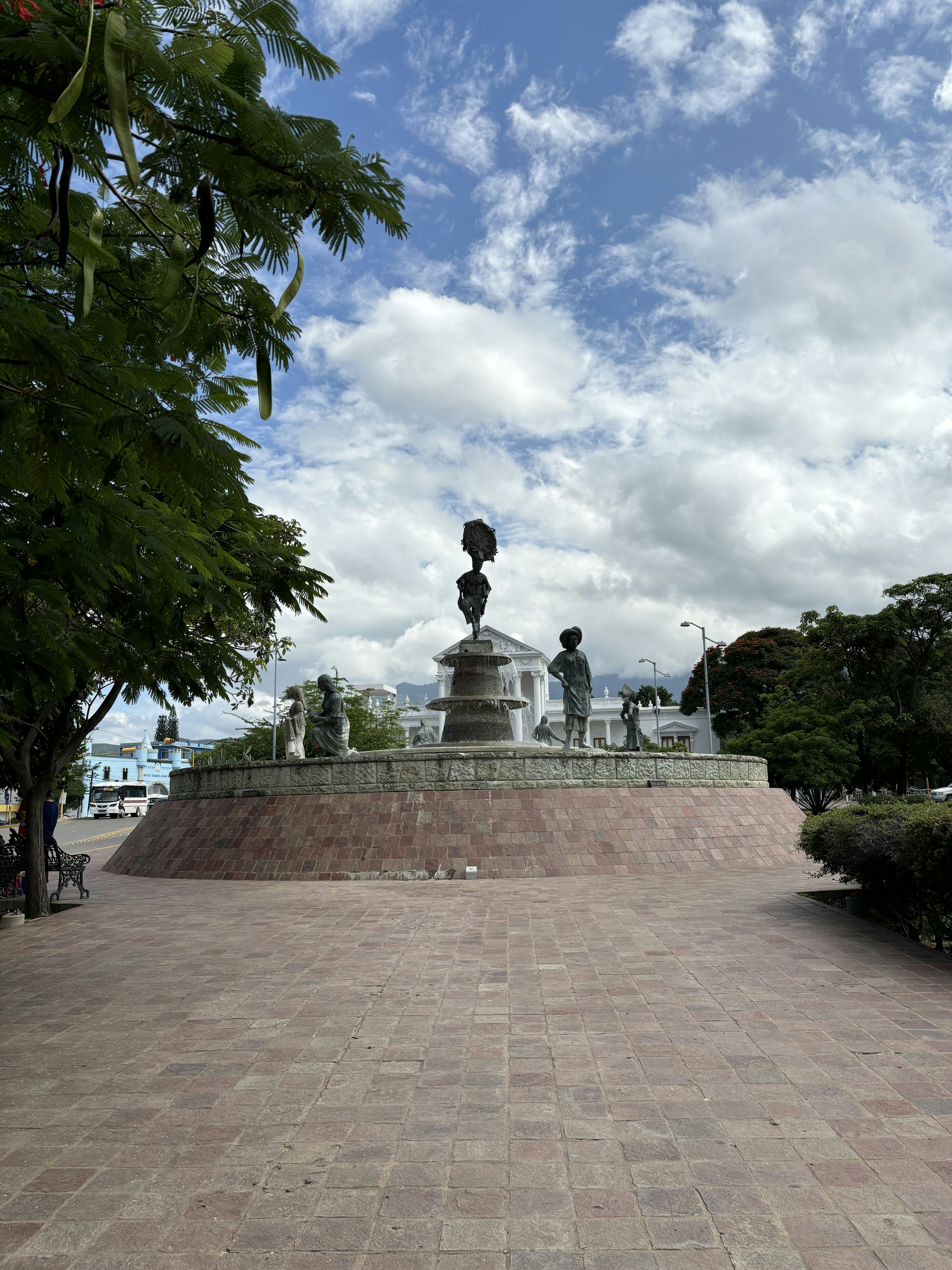 A statue in the middle of a brick walkway