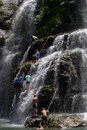 A group of people standing in front of a waterfall