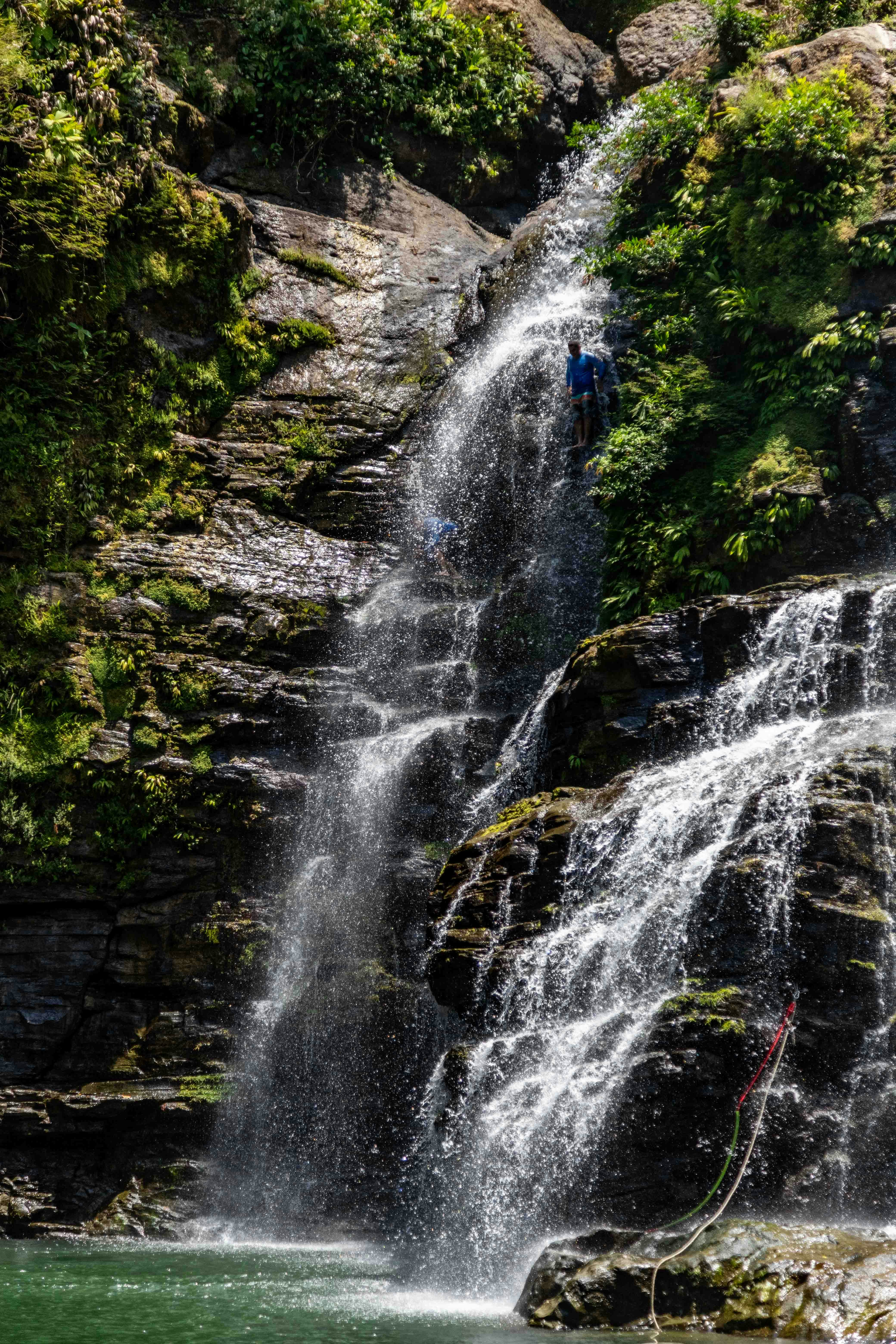 A man standing in front of a waterfall