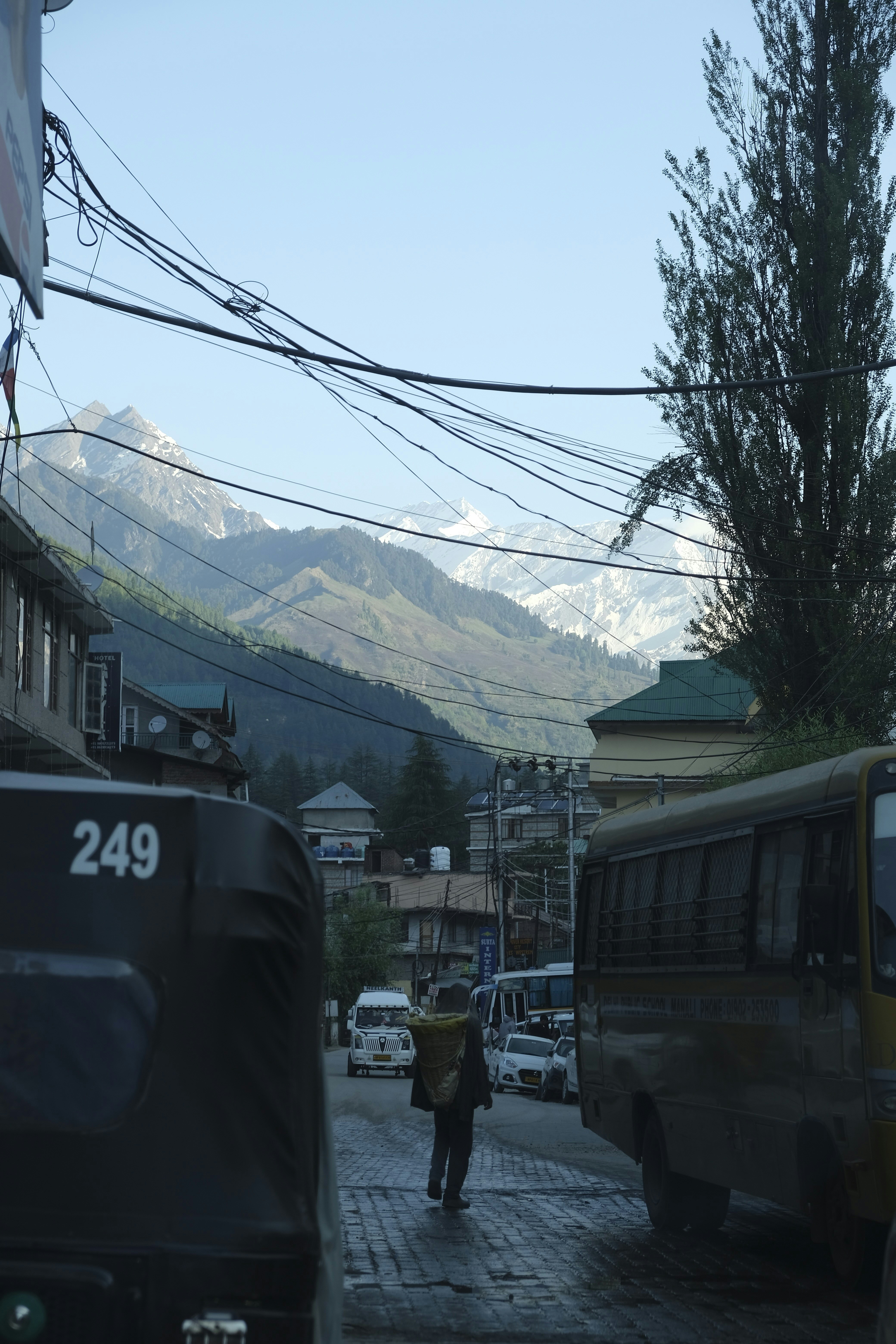A man walking down a street next to a bus