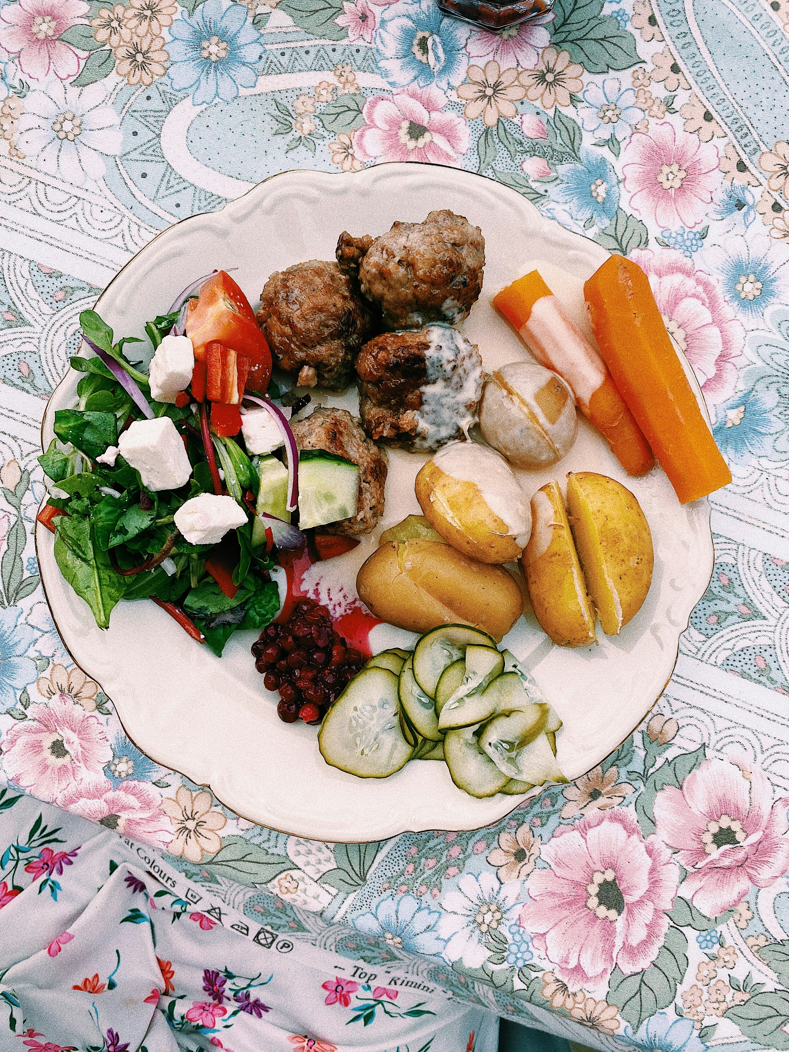 A white plate topped with meat and vegetables