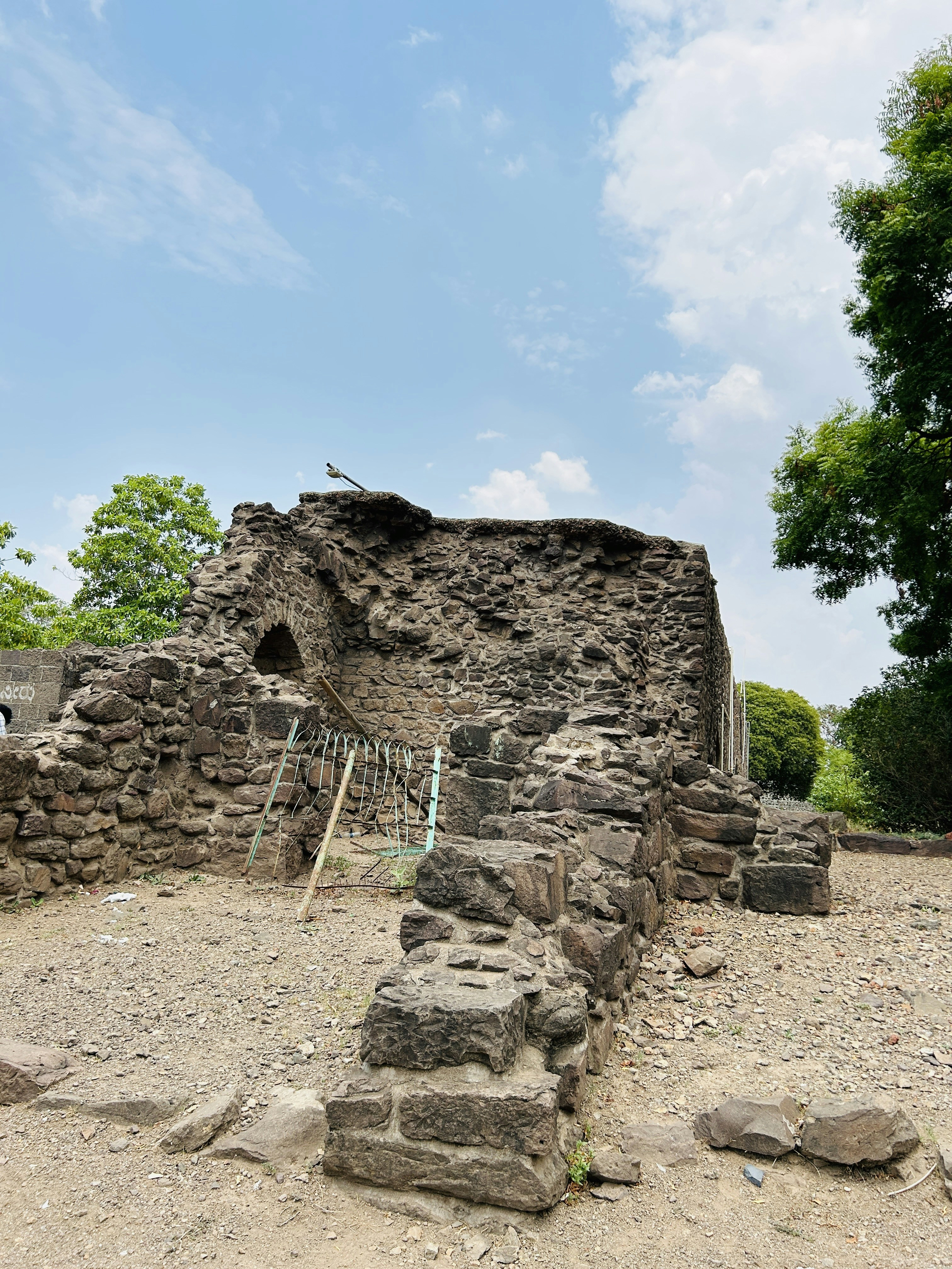 A stone building sitting on top of a dirt field