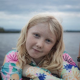 A little girl sitting on a boat in the water