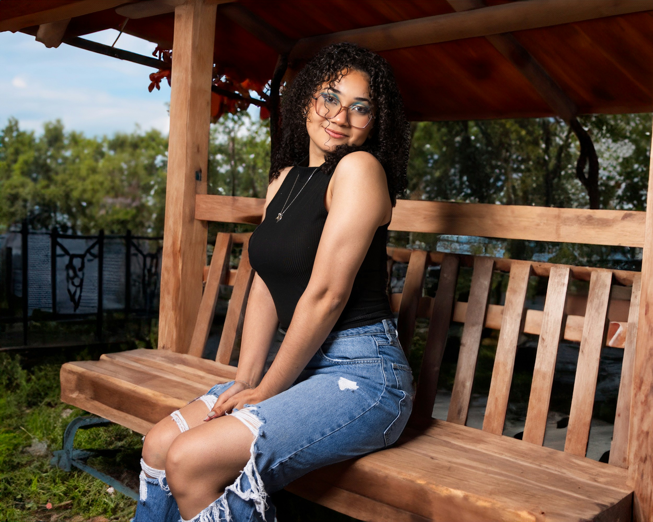 A woman sitting on a wooden bench in a park