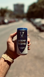 A hand holding a can of great taste