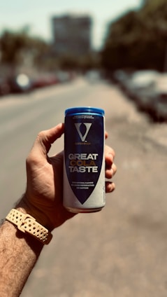 A hand holding a can of great taste