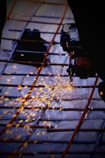 A person using a grinder on a piece of metal