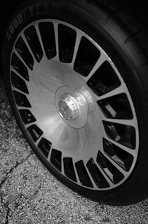 A black and white photo of a wheel on a car