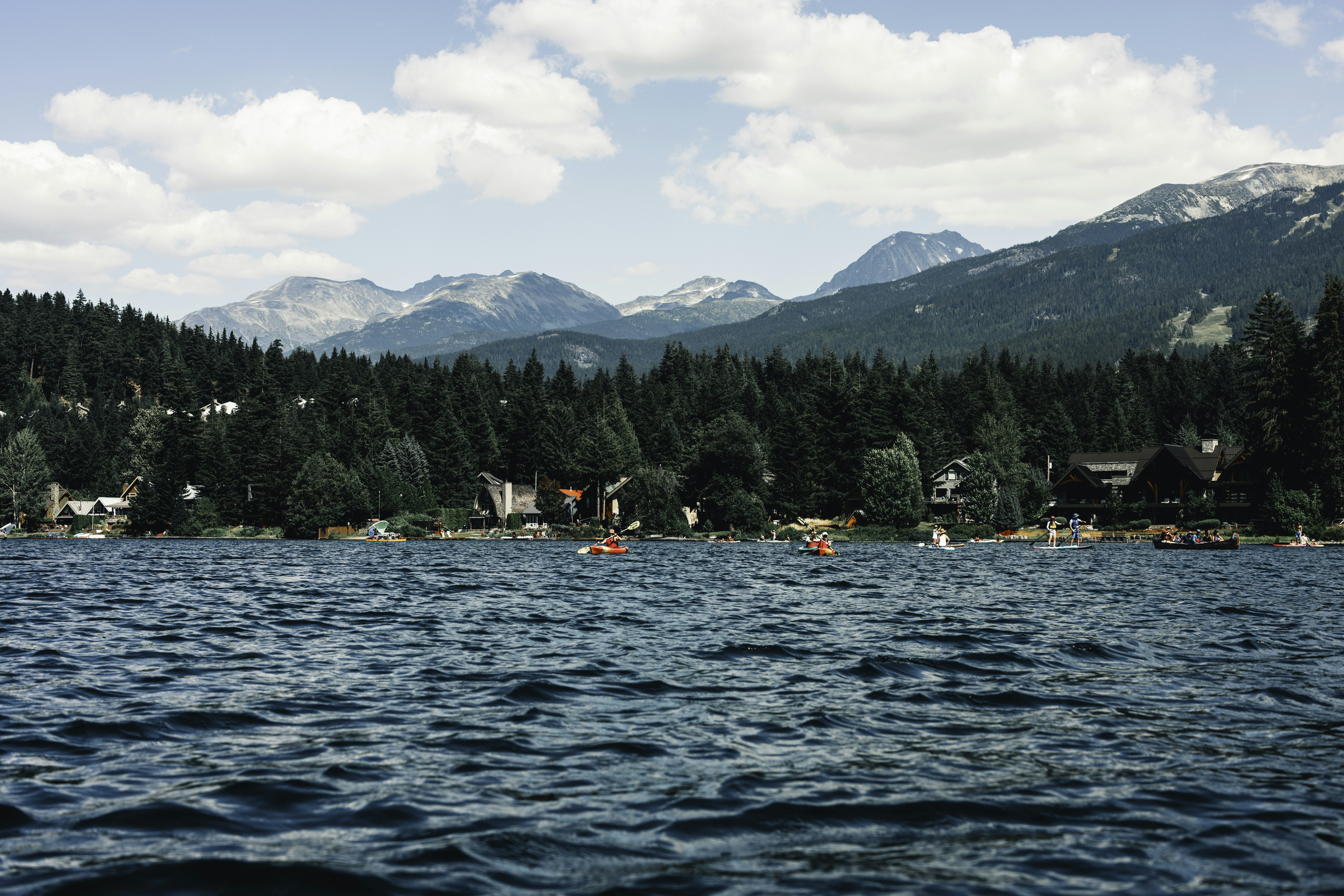Tour guides preparing kayaks and gear on a Whistler lake dock