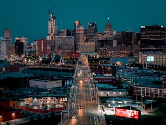 A view of a city at night from the top of a hill