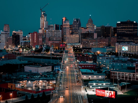A view of a city at night from the top of a hill