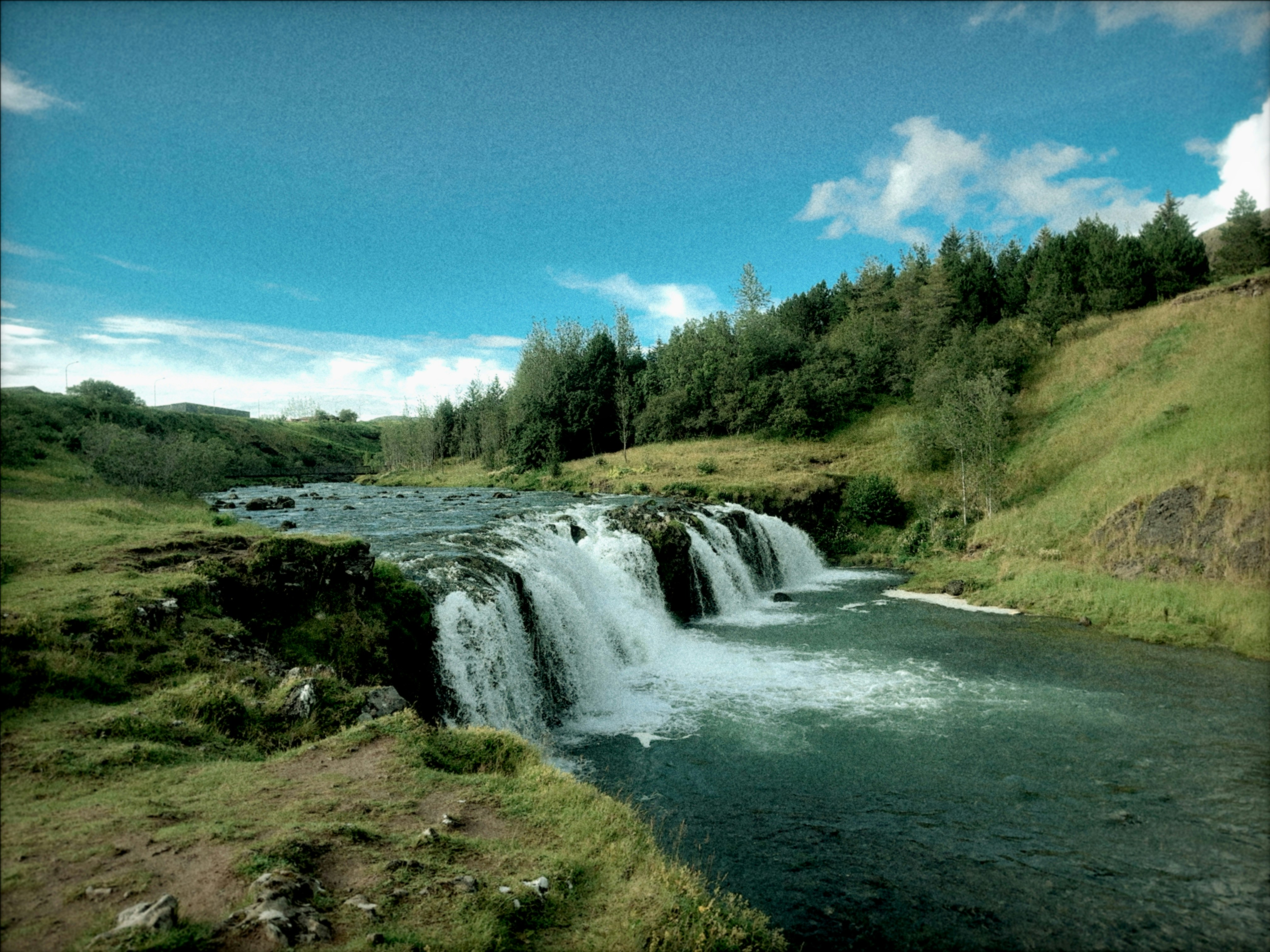 A small waterfall in the middle of a field photo – Free Iceland Image ...