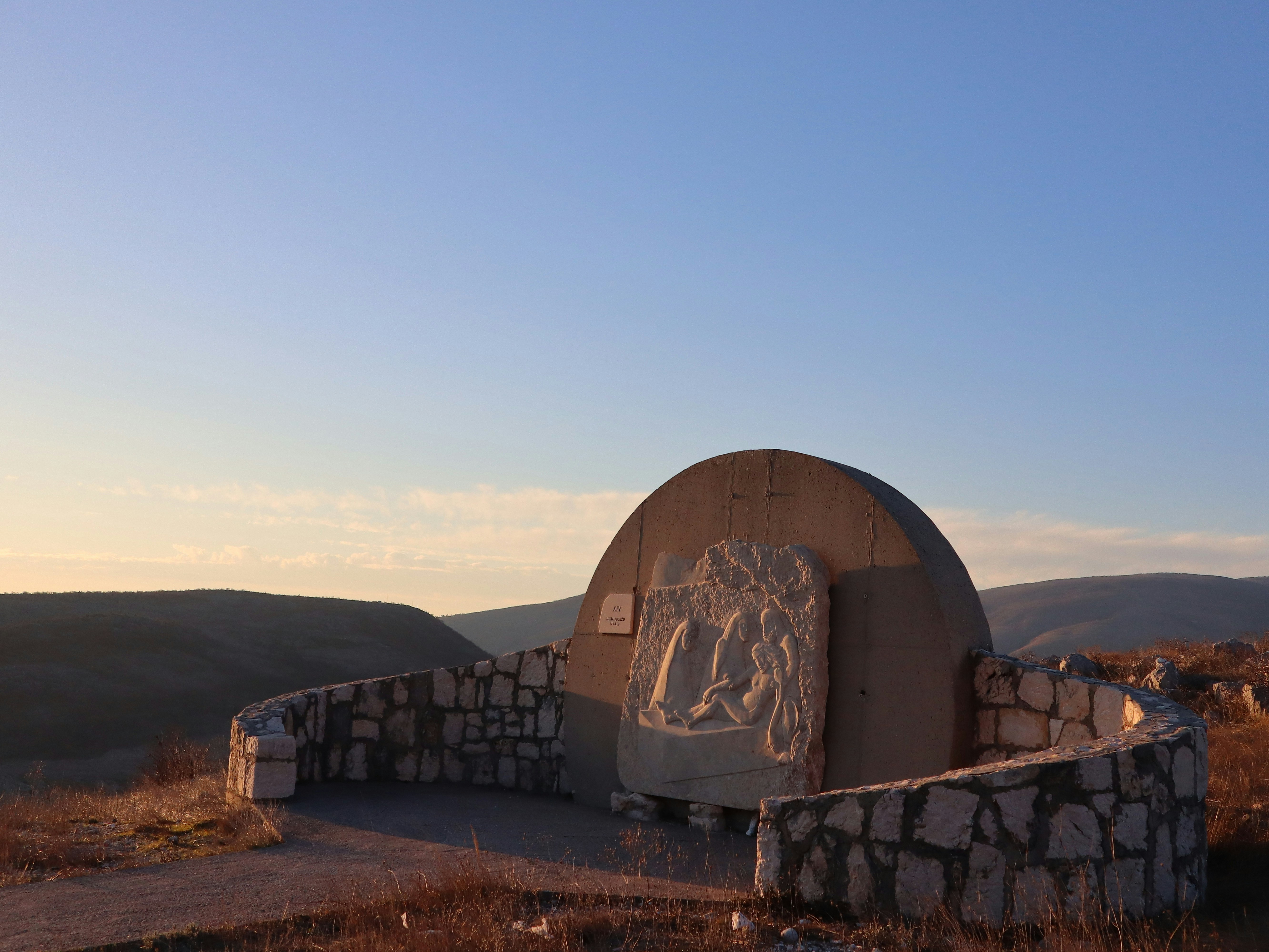 A large stone structure with a statue on top of it, 
