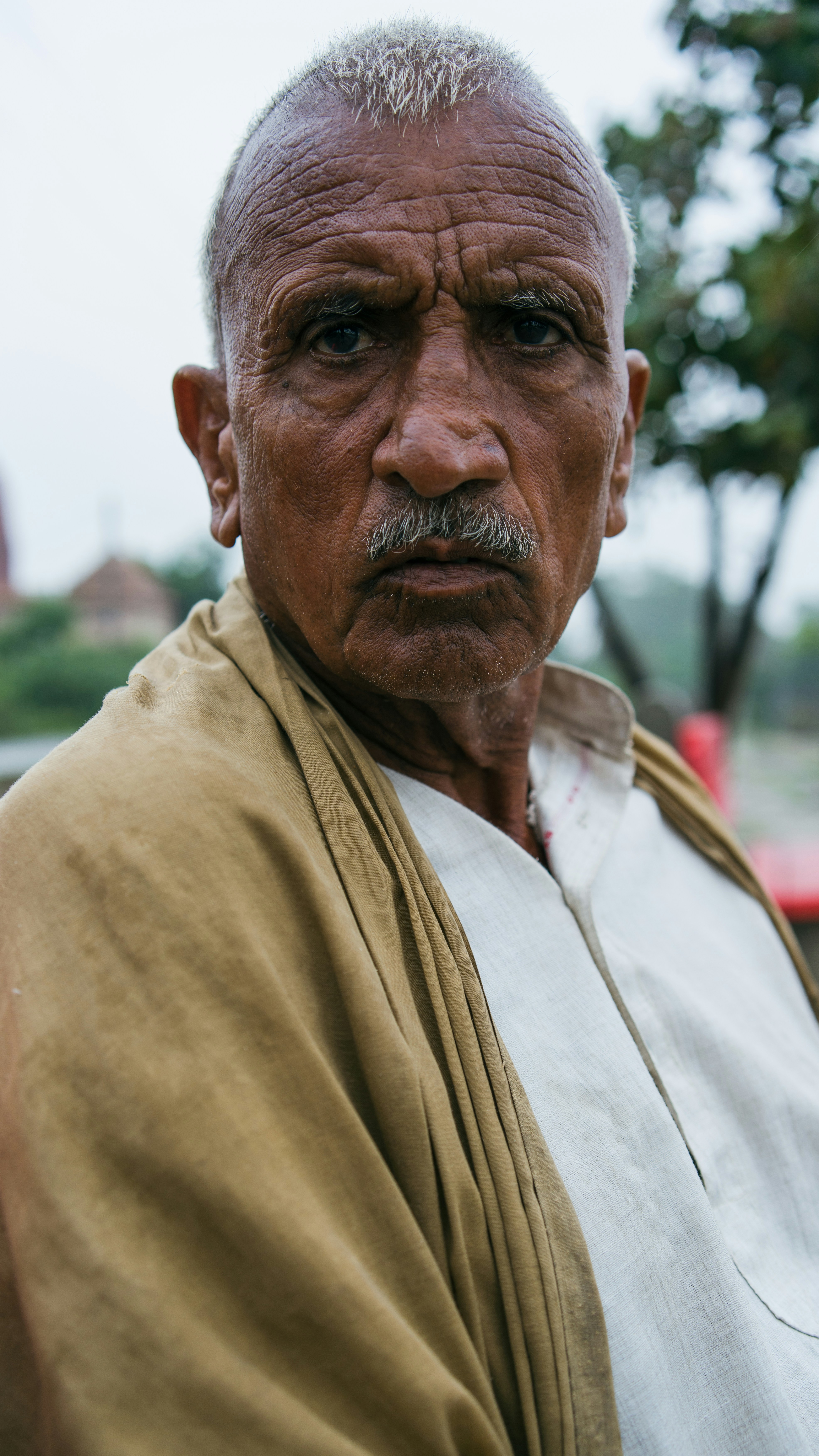 A man with a white beard and a tan shawl