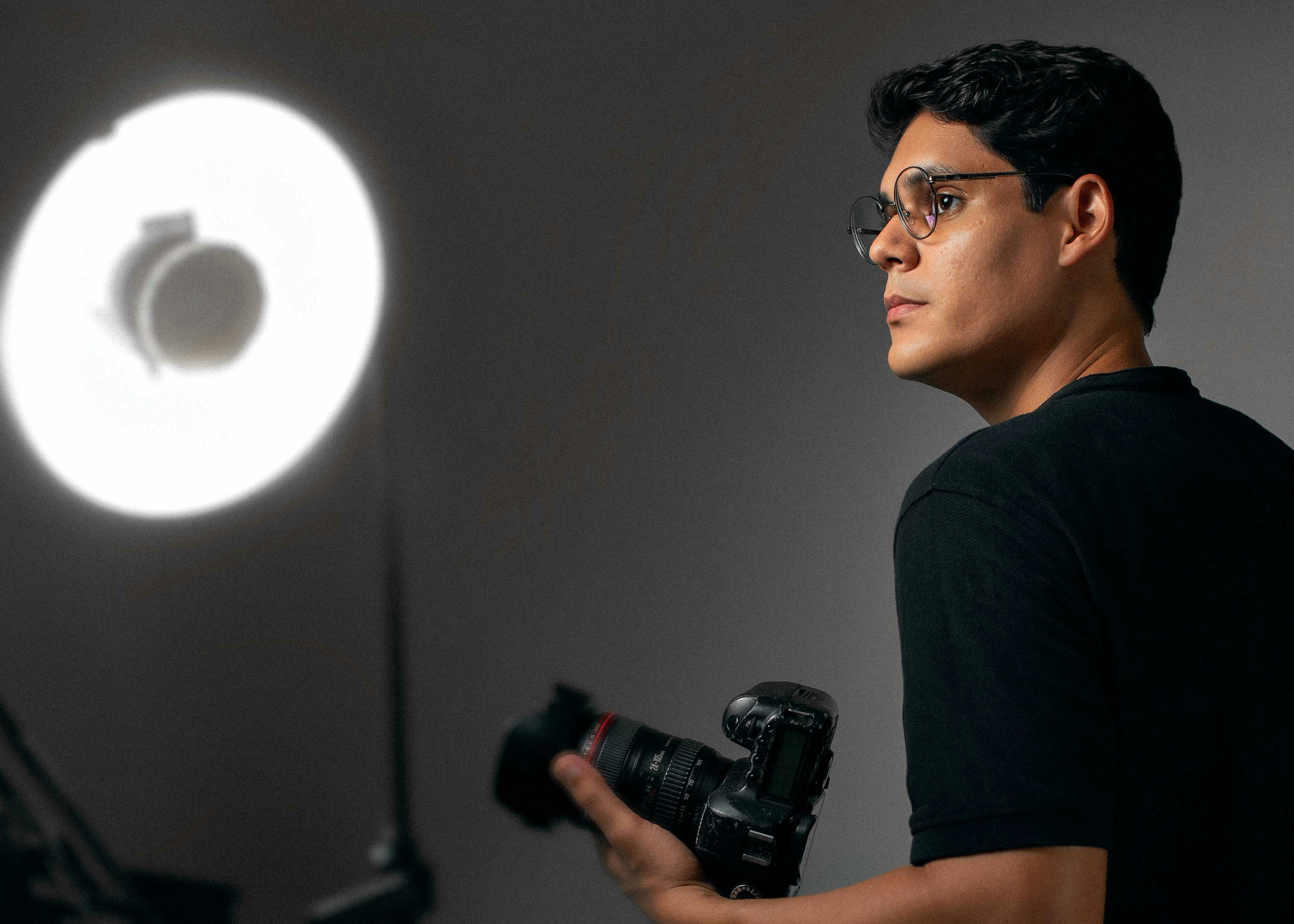 A man holding a camera in front of a light