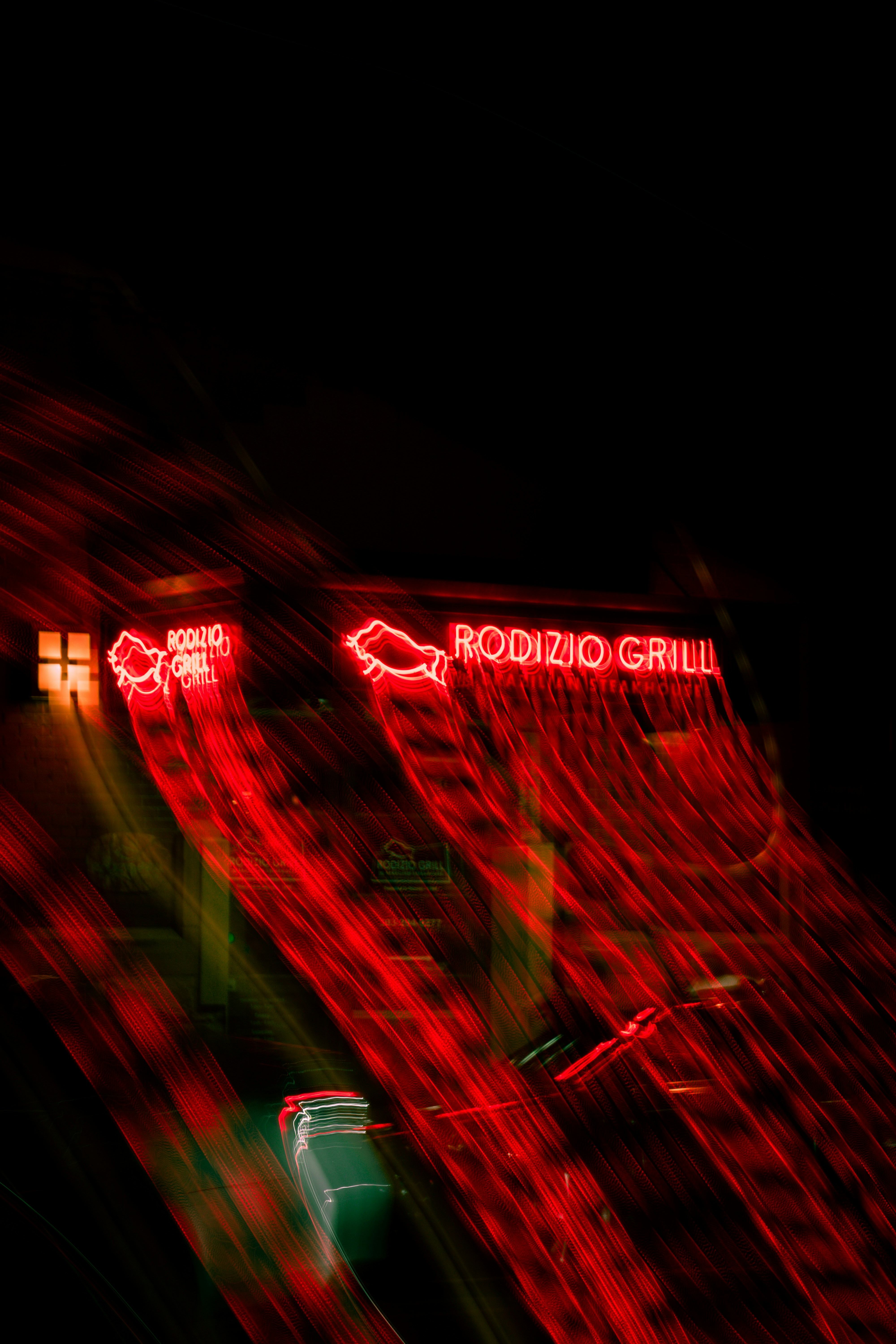 A red neon sign that is on the side of a building