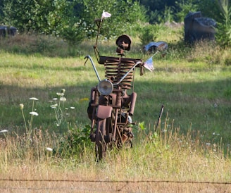 Uma escultura de um homem segurando uma bandeira em cima de uma motocicleta.