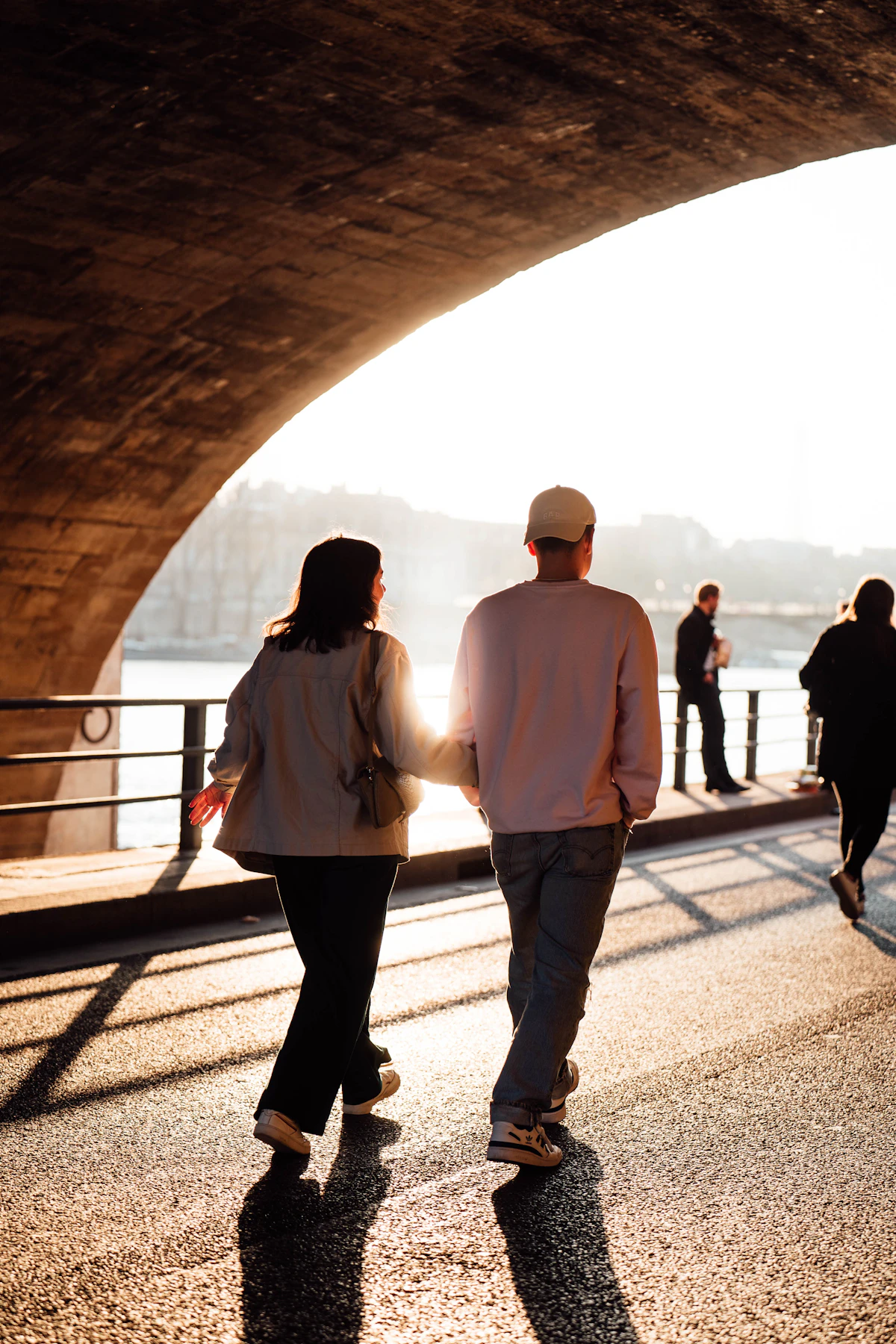 Menschen gehen entspannt gemeinsam unter einer Brücke als Symbol für einen normalen rauchfreien Alltag