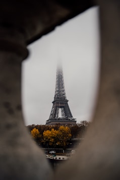 A view of the eiffel tower through a hole in a wall