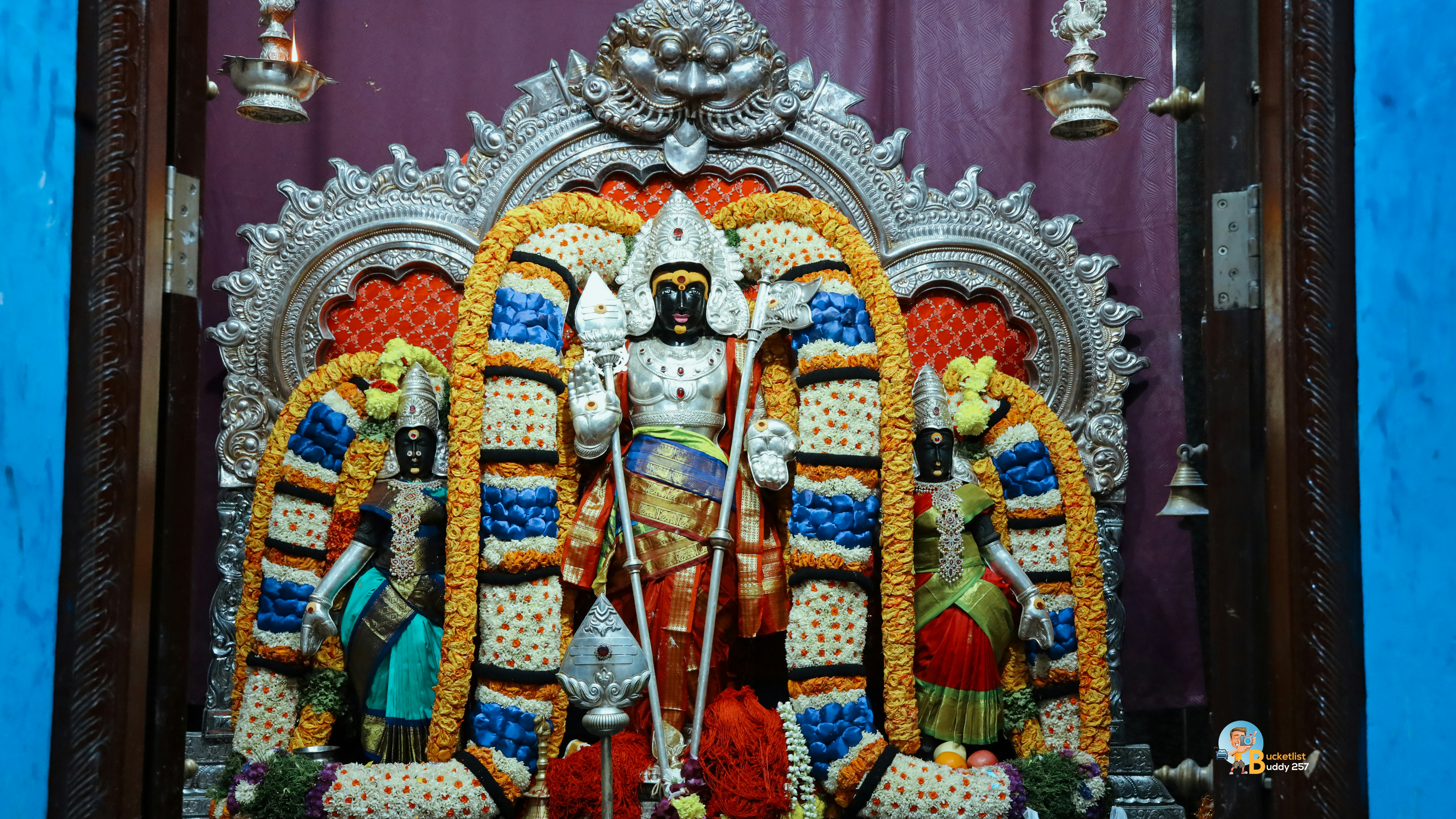 A statue of a god in front of a blue wall