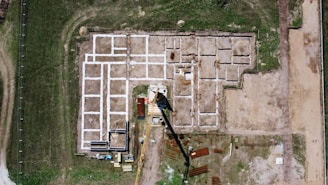 An aerial view of a building site in the middle of a field