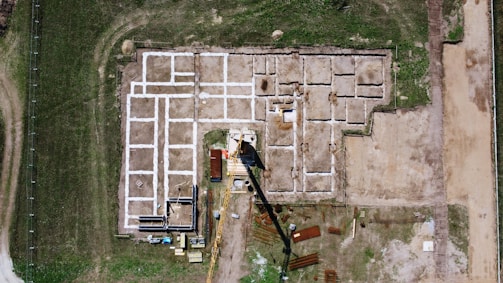 An aerial view of a building site in the middle of a field