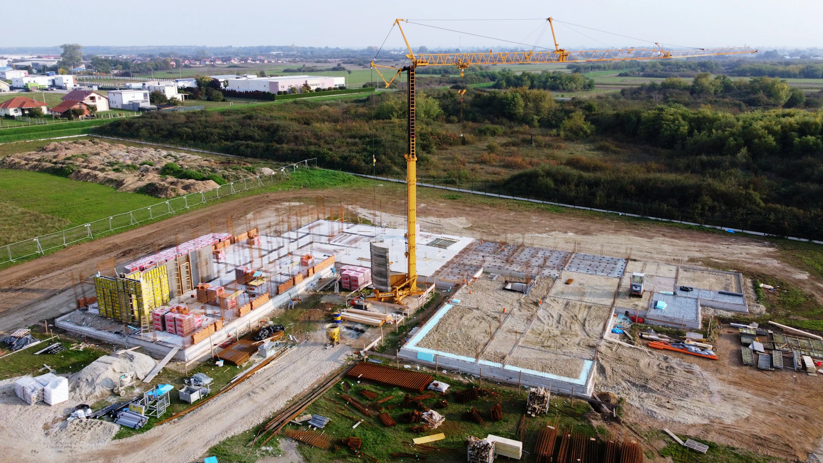 A construction site with a tower crane, seen from above