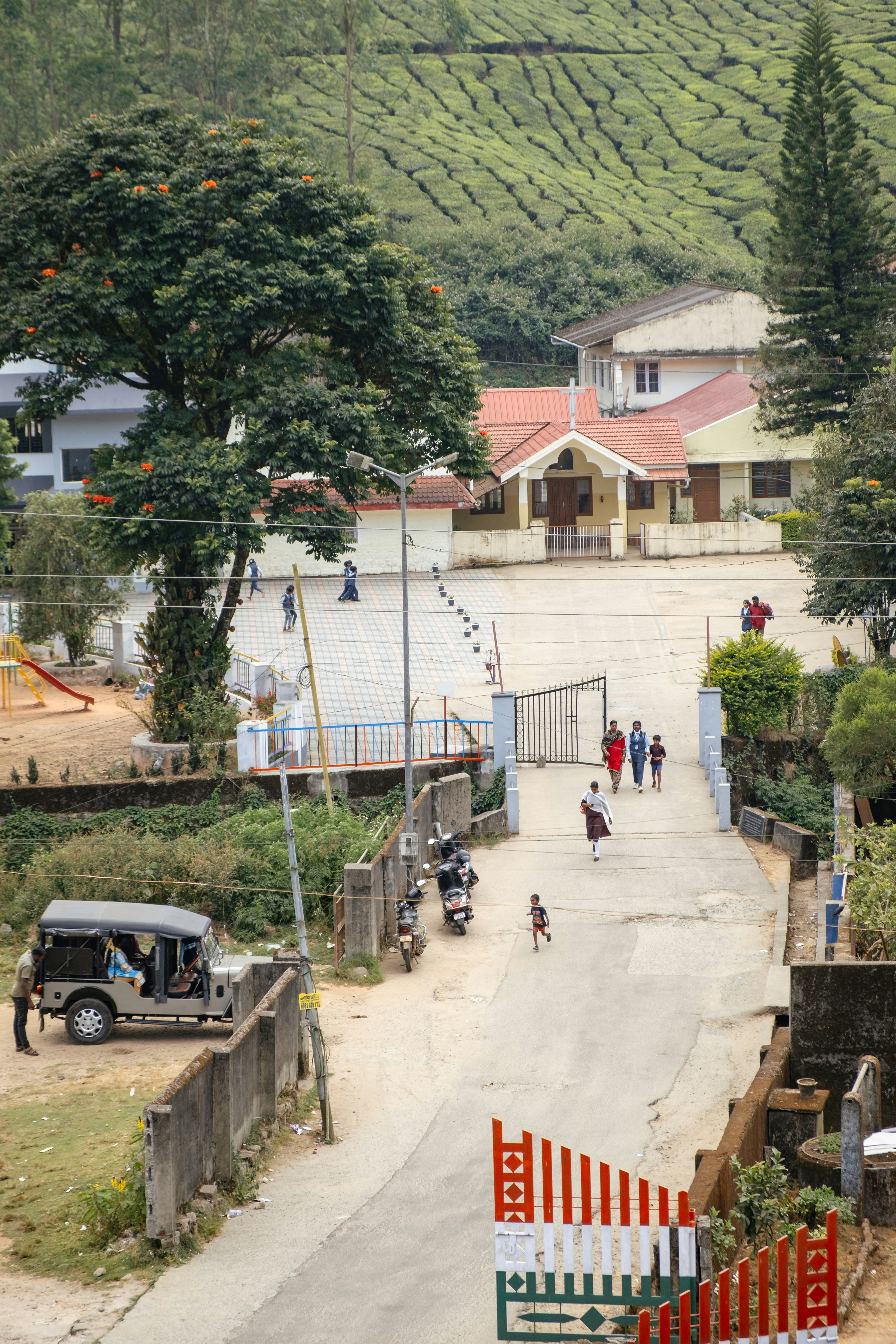 A small village with a dirt road and a hill in the background
