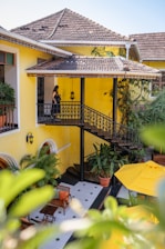 A yellow house with a yellow umbrella in front of it
