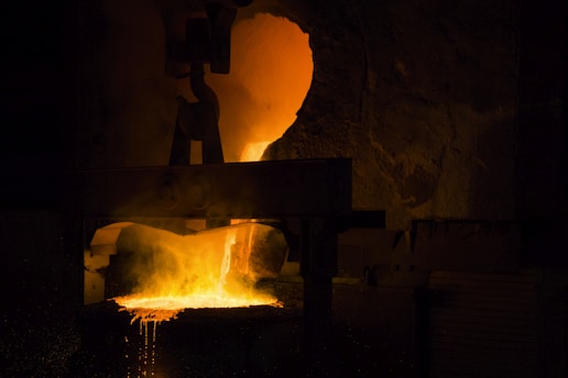 A man standing in front of a metal furnace