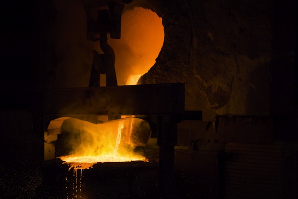 A man standing in front of a metal furnace