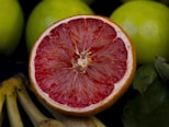 A grapefruit cut in half next to bananas